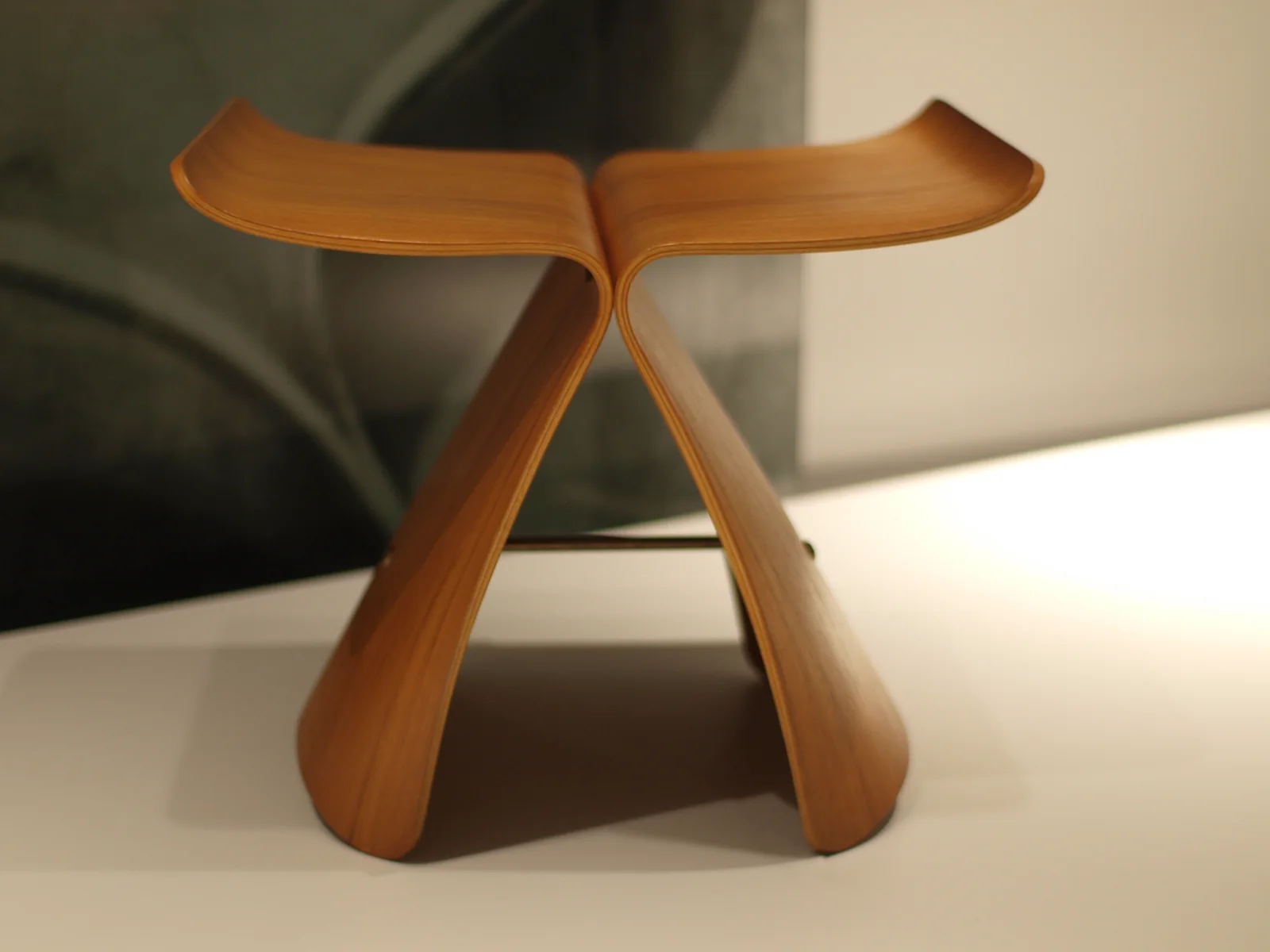 Sori Yanagi Butterfly stool viewed from the front, showing two mirrored curved plywood shells that form the seat and legs and meet around a central connector