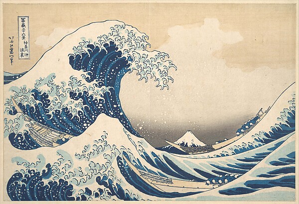 A towering blue wave curls above three narrow boats while snow-capped Mount Fuji appears small in the distance